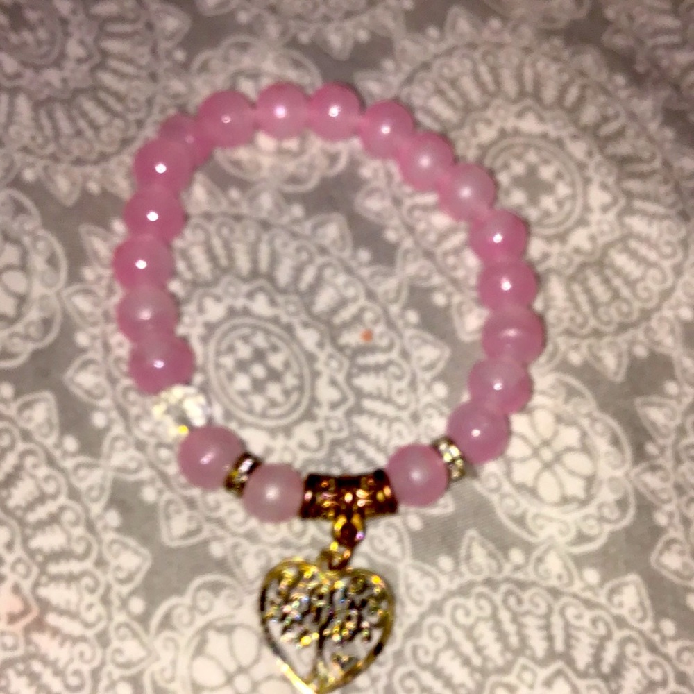 I am selling a pink bracelet with clear beads and a beautiful gold charm